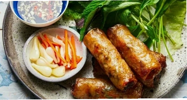 Đĩa chả giò rế vàng óng ánh trên bàn tiệc